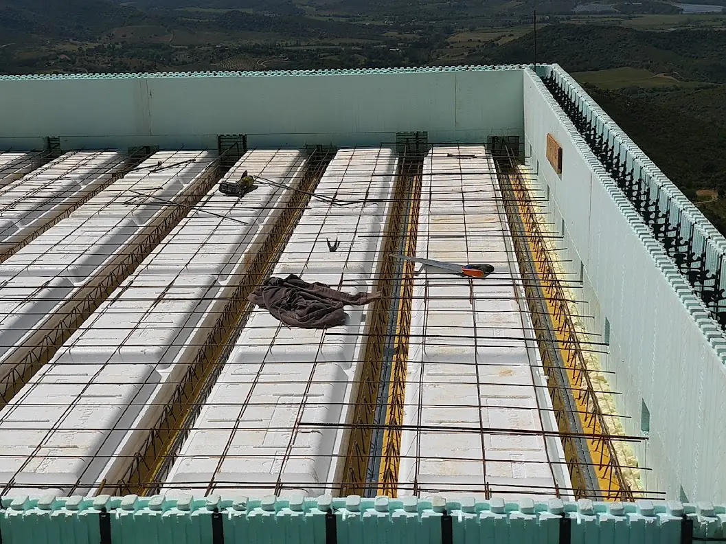 Plancher poutrelles et entrevous isolants avec treillis d'armature, ceinturé par les murs Nudura